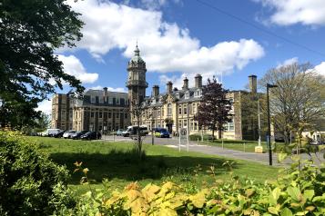 Cossham Hospital and grounds on a sunny day.