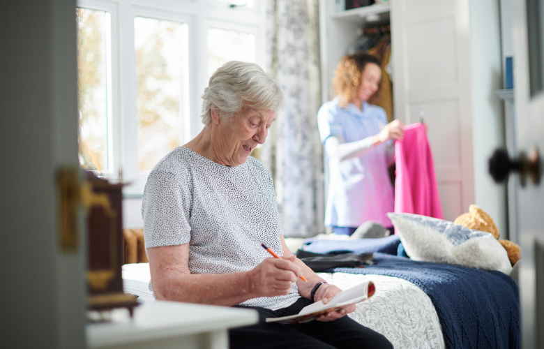 A carer helping an older woman in her home.